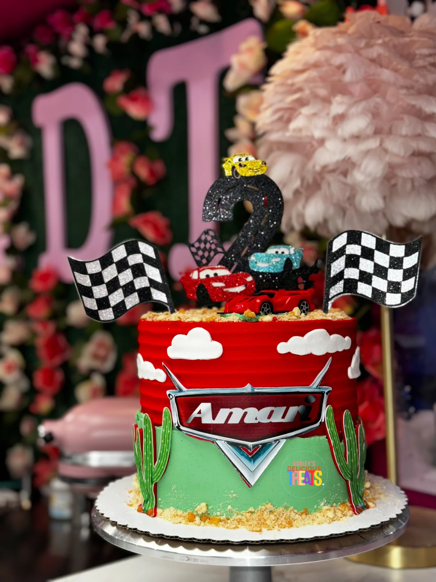 Cars-themed birthday cake with checkered flags and red and green buttercream